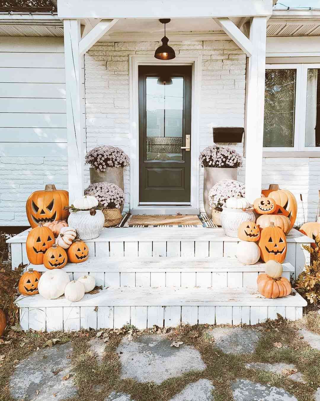 Λευκό τούβλινο σπίτι με κολοκύθες και Jack-o'-Lanterns στη βεράντα