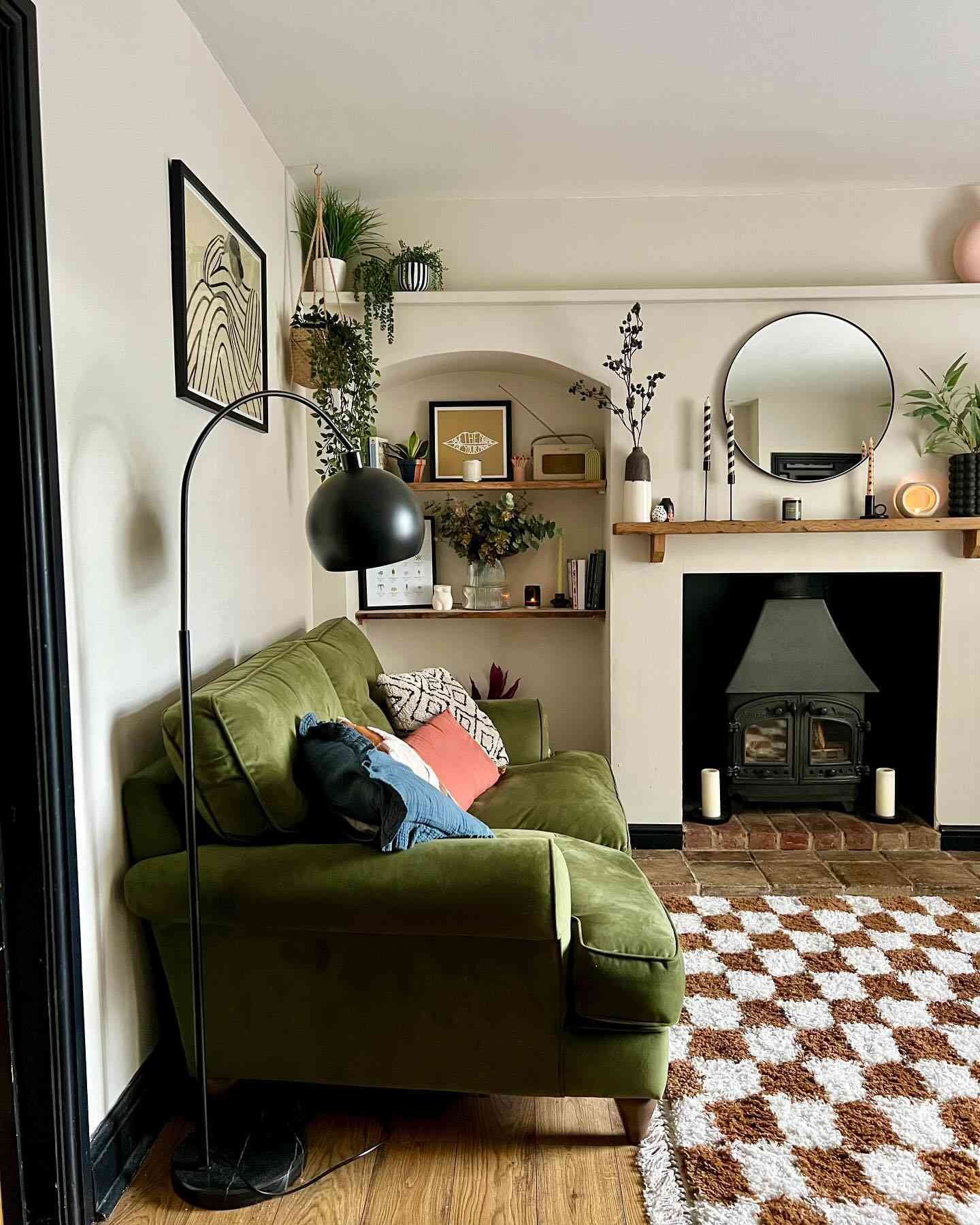 sage green velvet couch with greenery hanging from ceiling and shelves