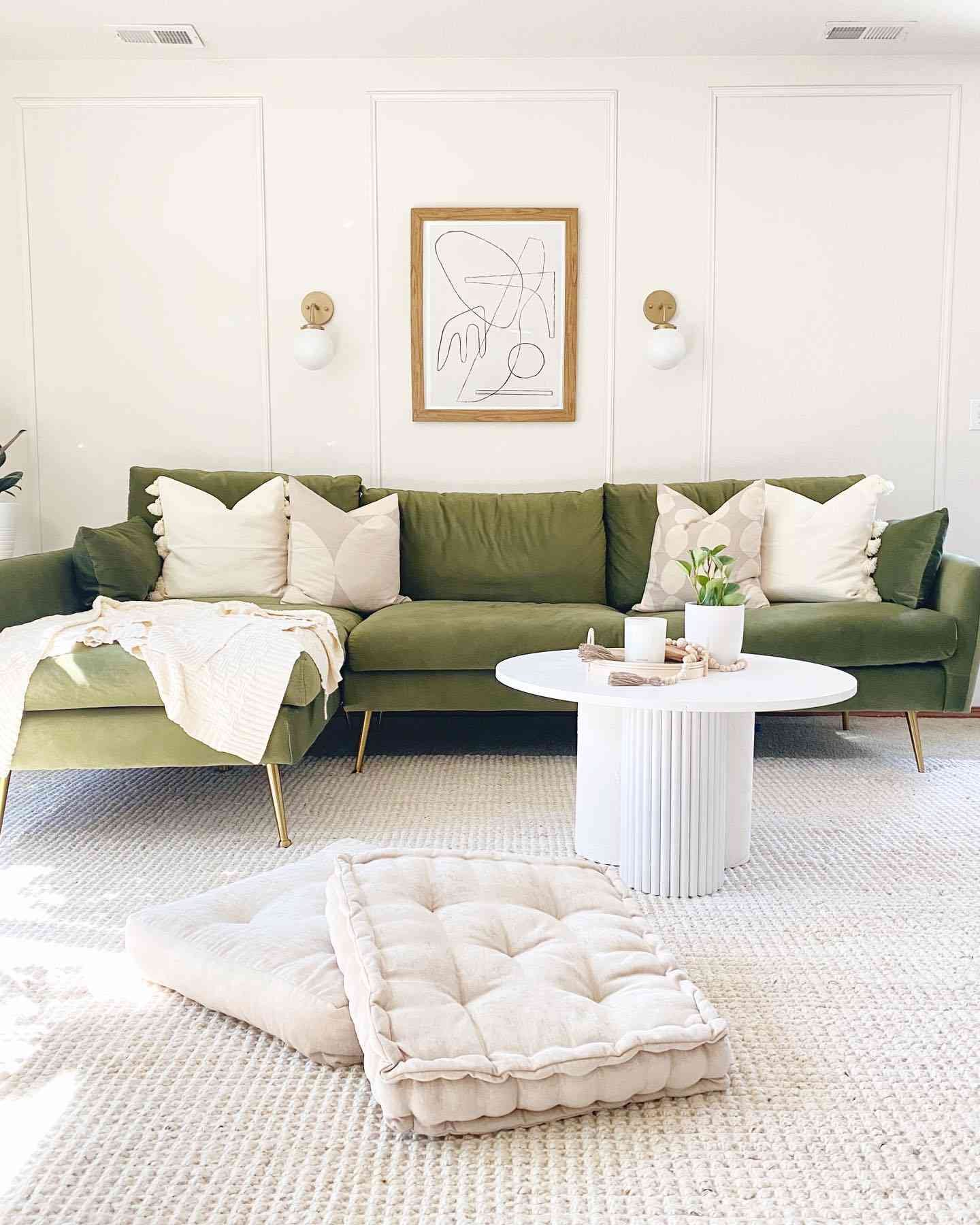 white living room with rich sage green couch 
