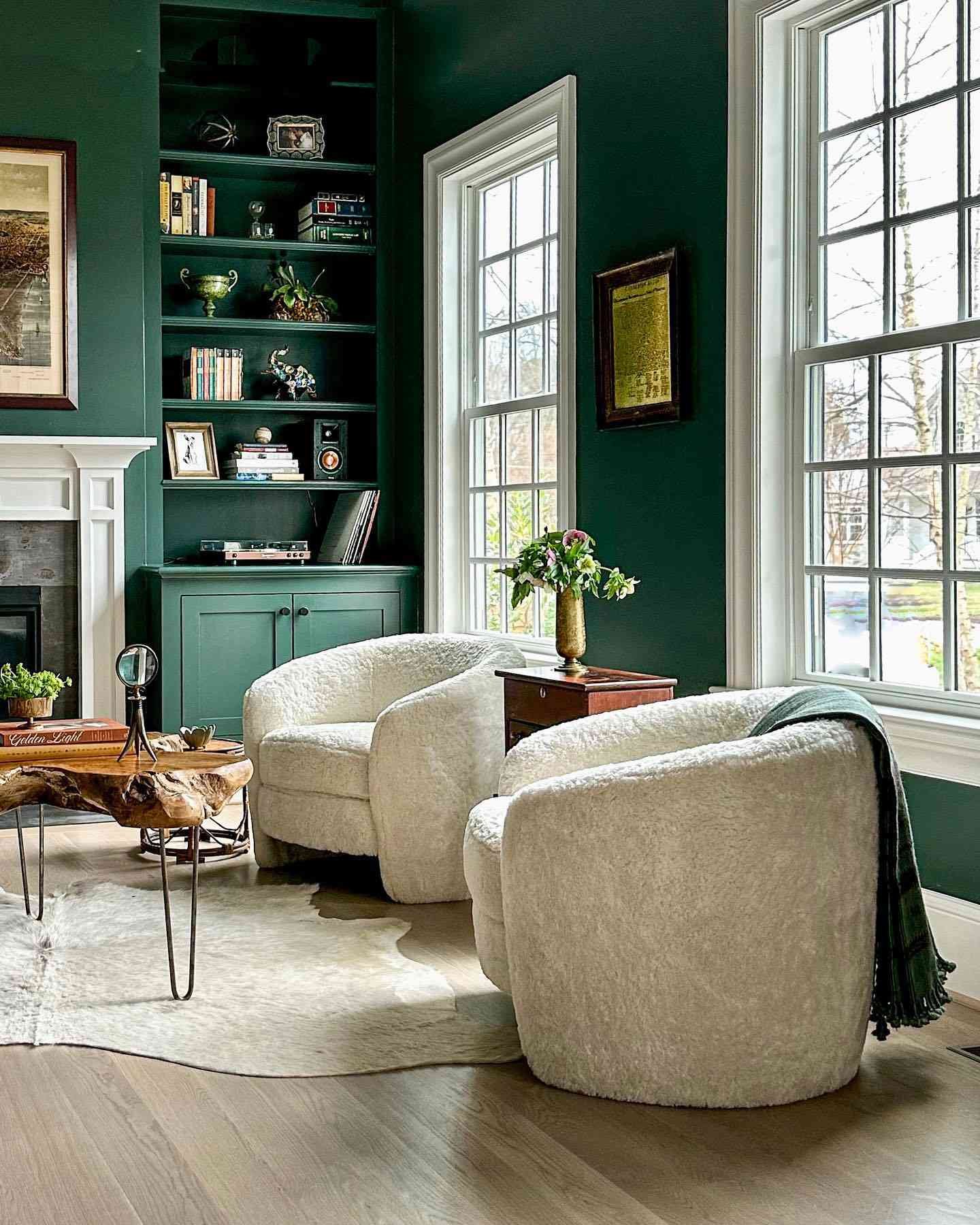 deep sage green living room with beige round chairs