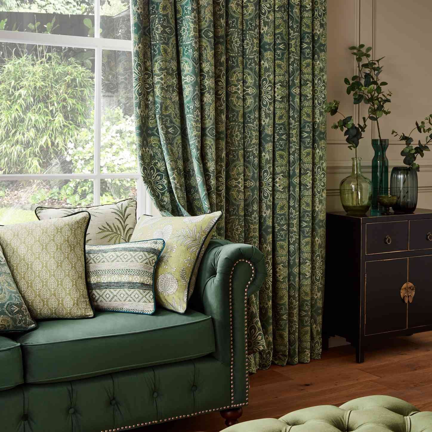 sage green couch with green floral curtains