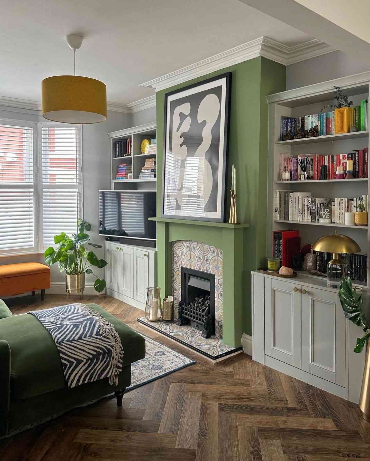 sage green living room with colorful books on built in