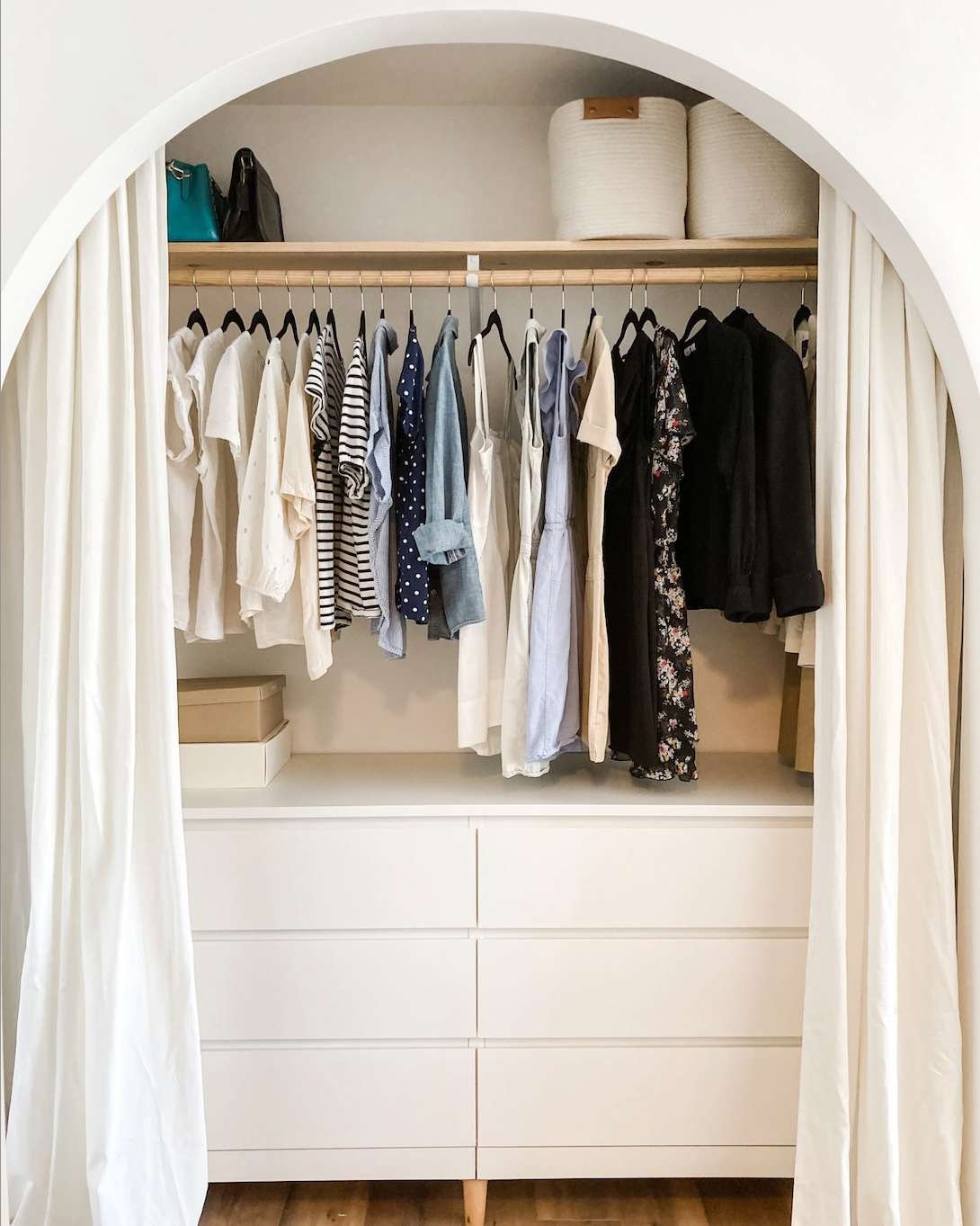 arched closet with white curtains