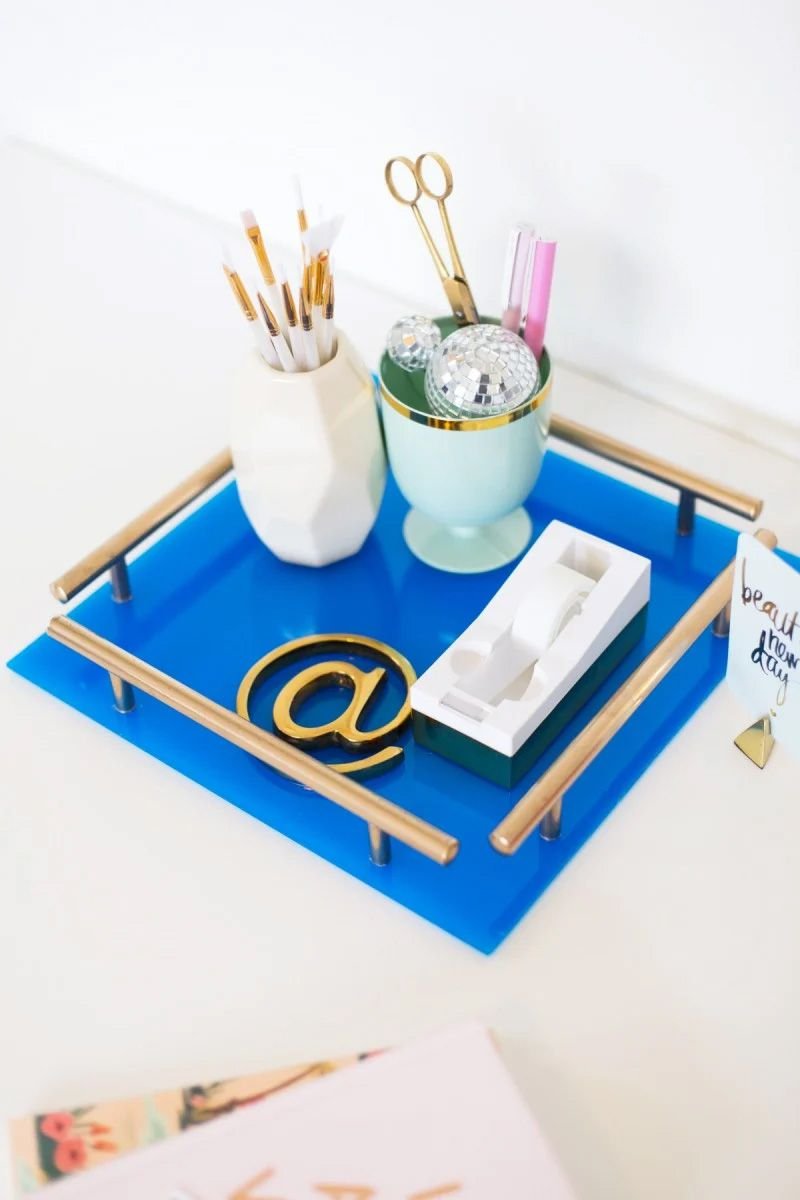 A blue acrylic tray with gold handles