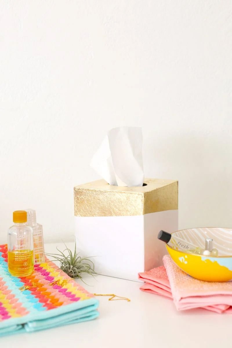 A white and gold tissue box in a bathroom