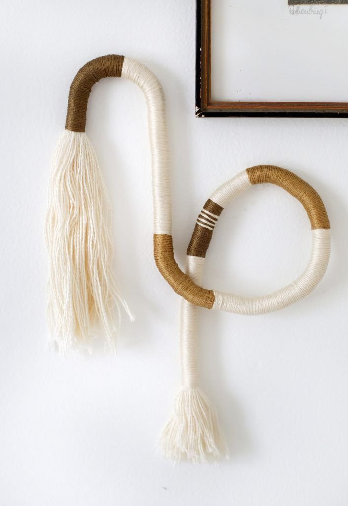 A brown and cream wrapped piece of art hanging on the wall