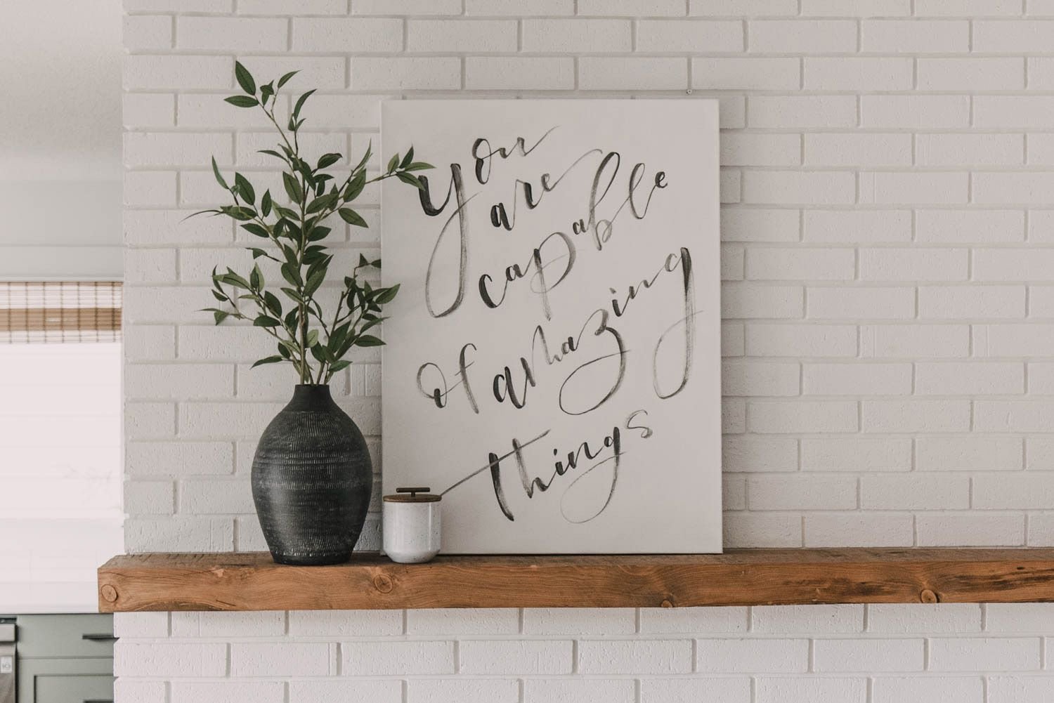 A canvas wall hanging on a mantel