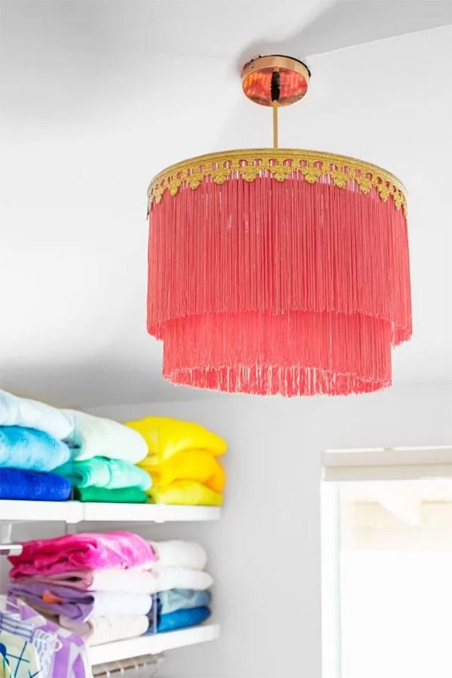 A orange fringe chandelier in a closet
