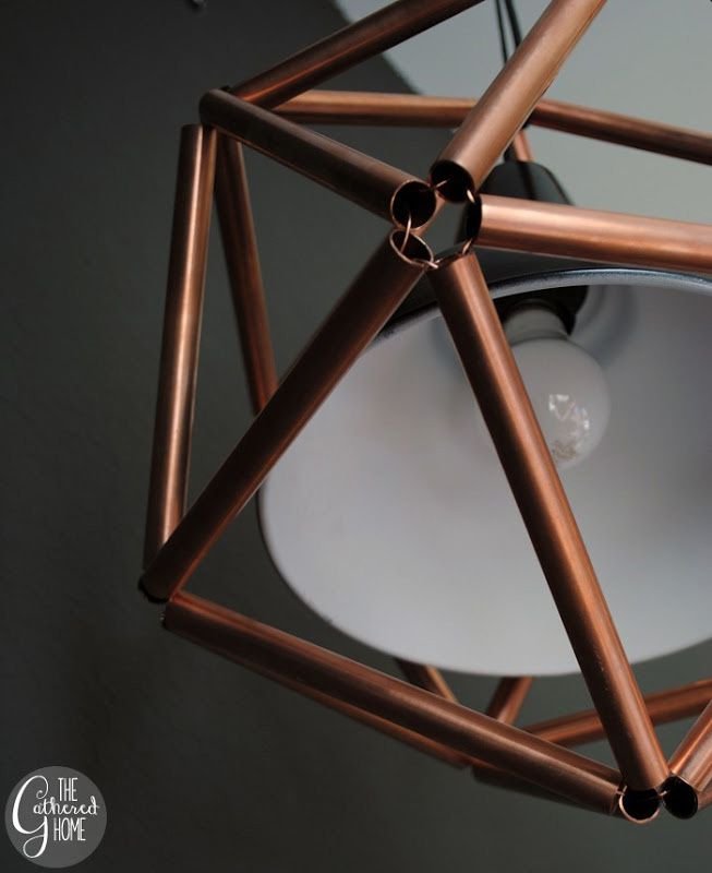 A close-up of a light fixture surrounding by copper piping