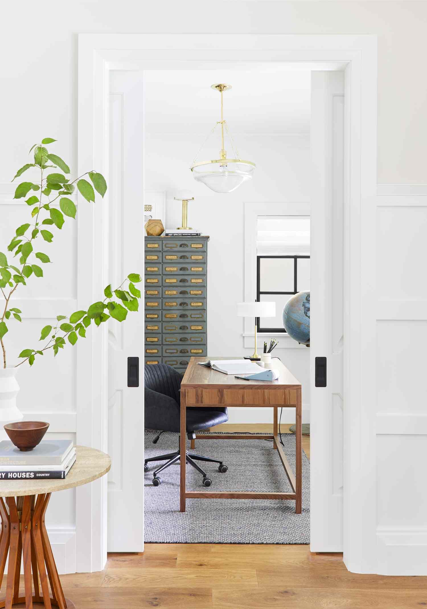 Glass shade pendant hanging in a vintage-inspired home office with filing cabinet and wood desk