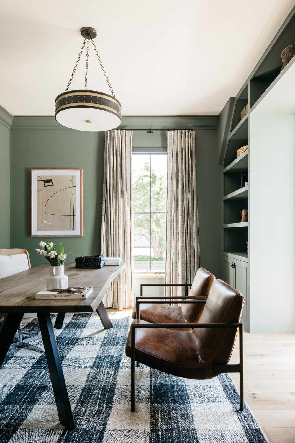 Statement pendant light in a home office with green walls