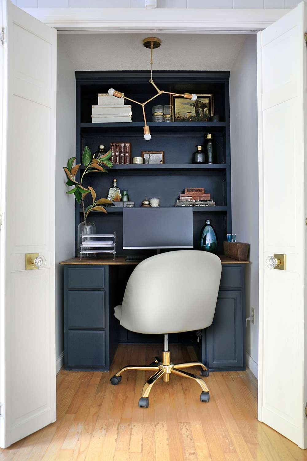 Closet turned into a home office with a geometric ceiling light fixture