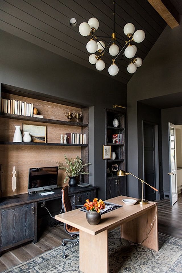 Industrial-style chandelier in a home office with dark walls and ceiling