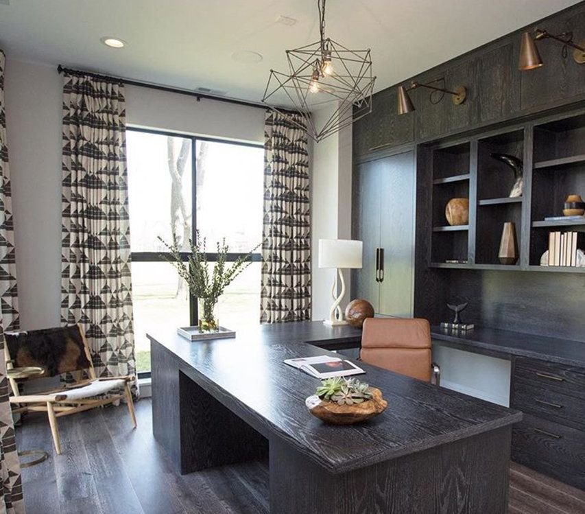 Sculptural ceiling light in an office with dark wood desk and built-ins