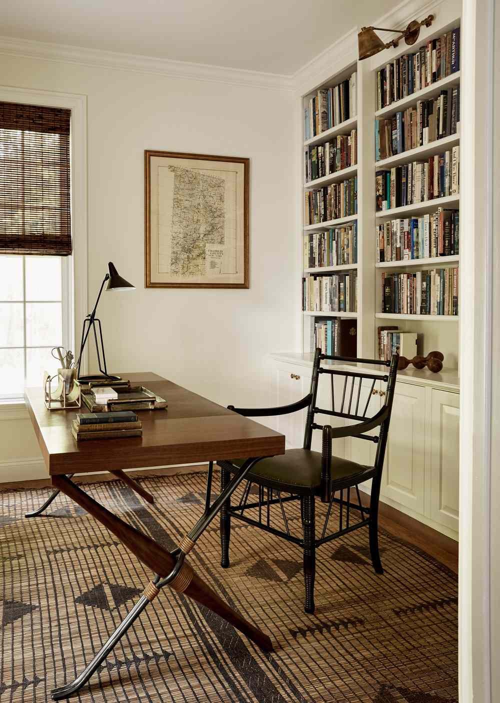 Black metal table lamp on a wood desk in a white home office