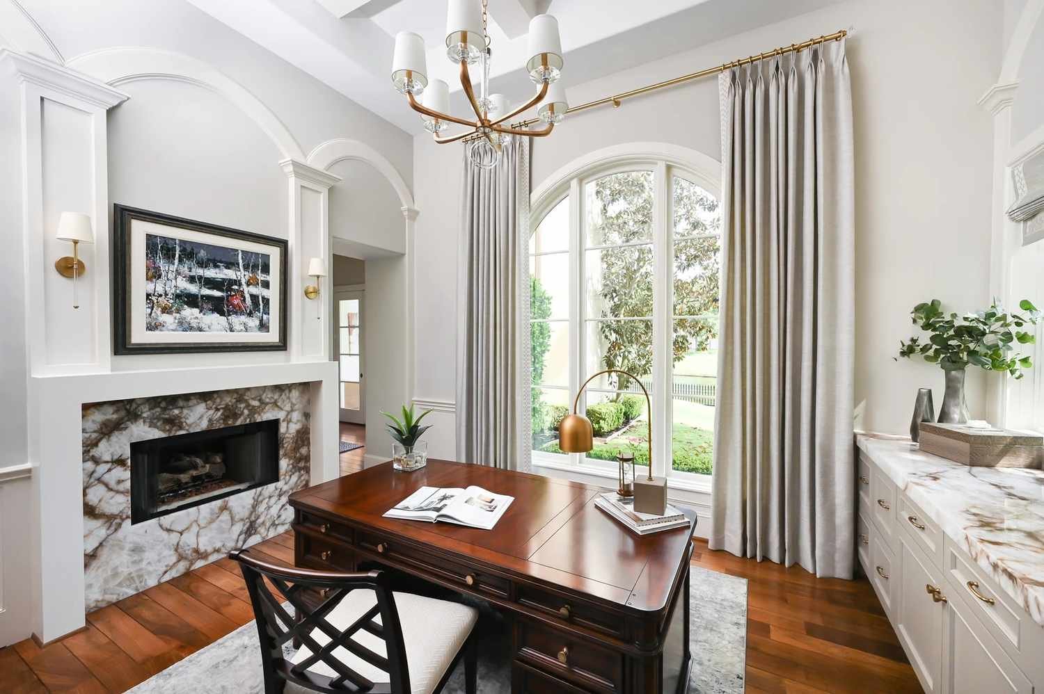 Brass arc table lamp on a wood desk in a traditional style home office