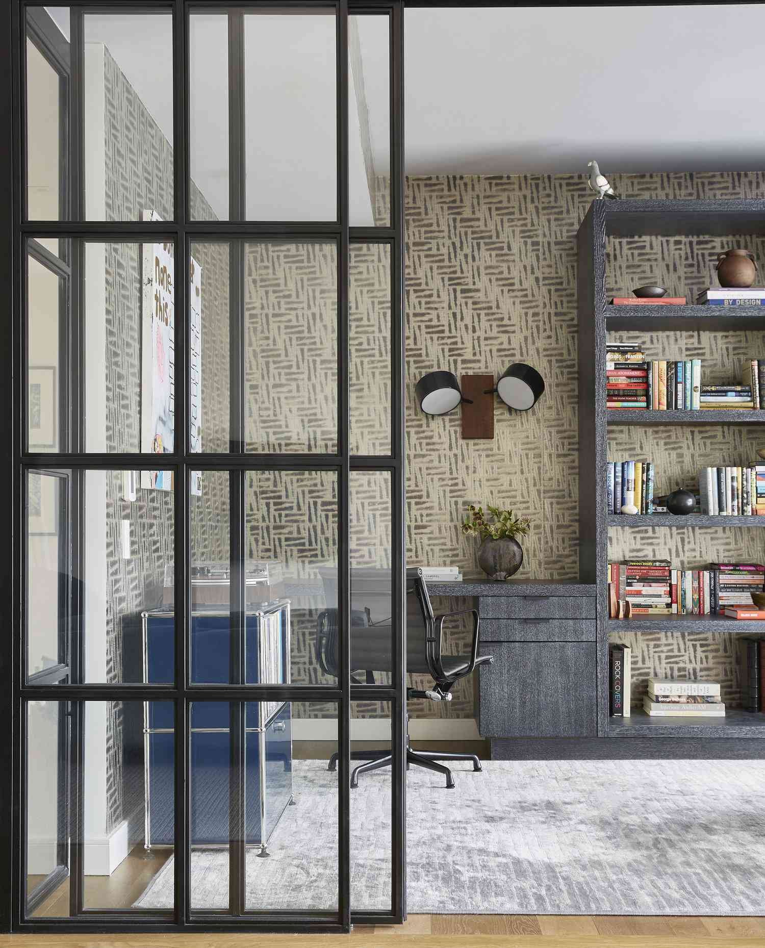 Modern wall sconce on a wallpapered wall above a desk in a home office