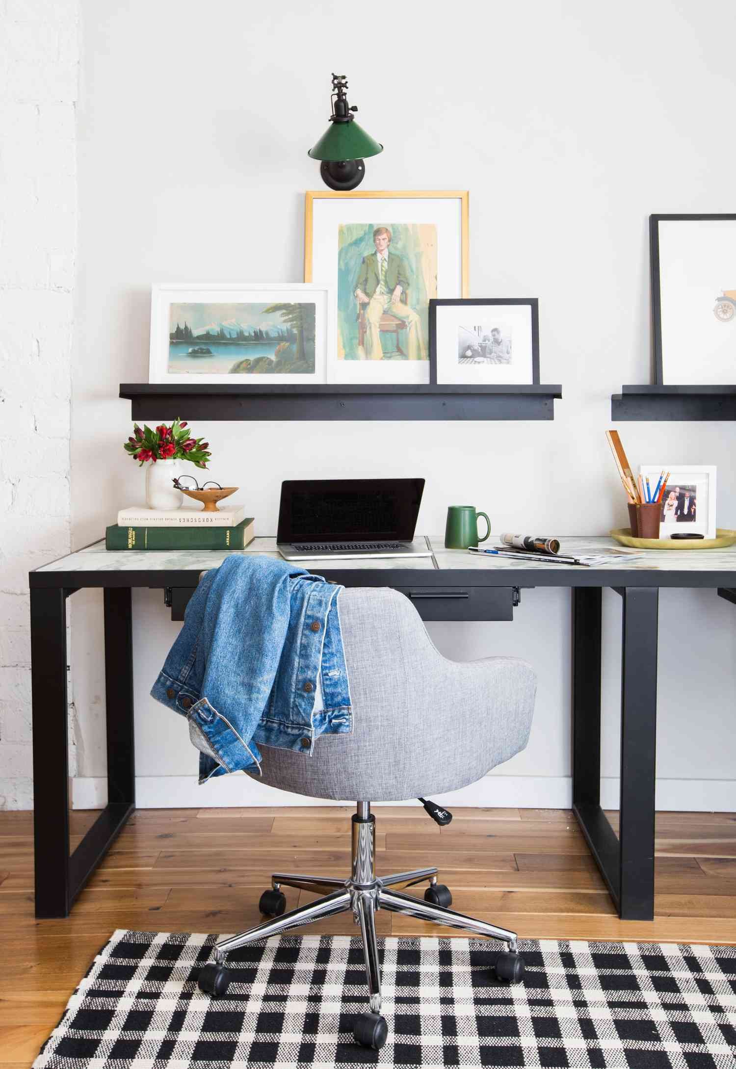 Green and black metal wall sconce above a desk and floating shelf