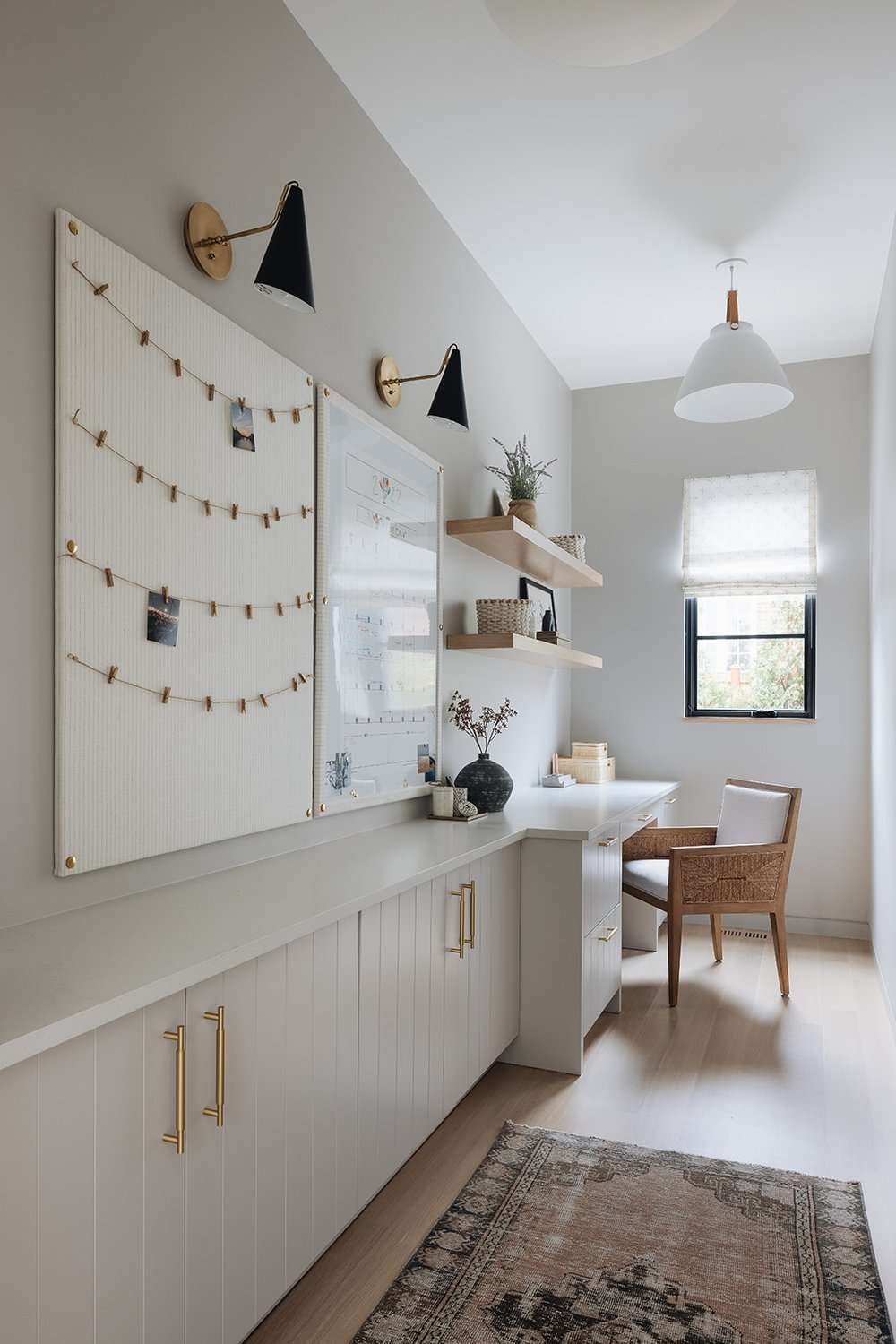 Two black wall sconces and a white pendant light in an office